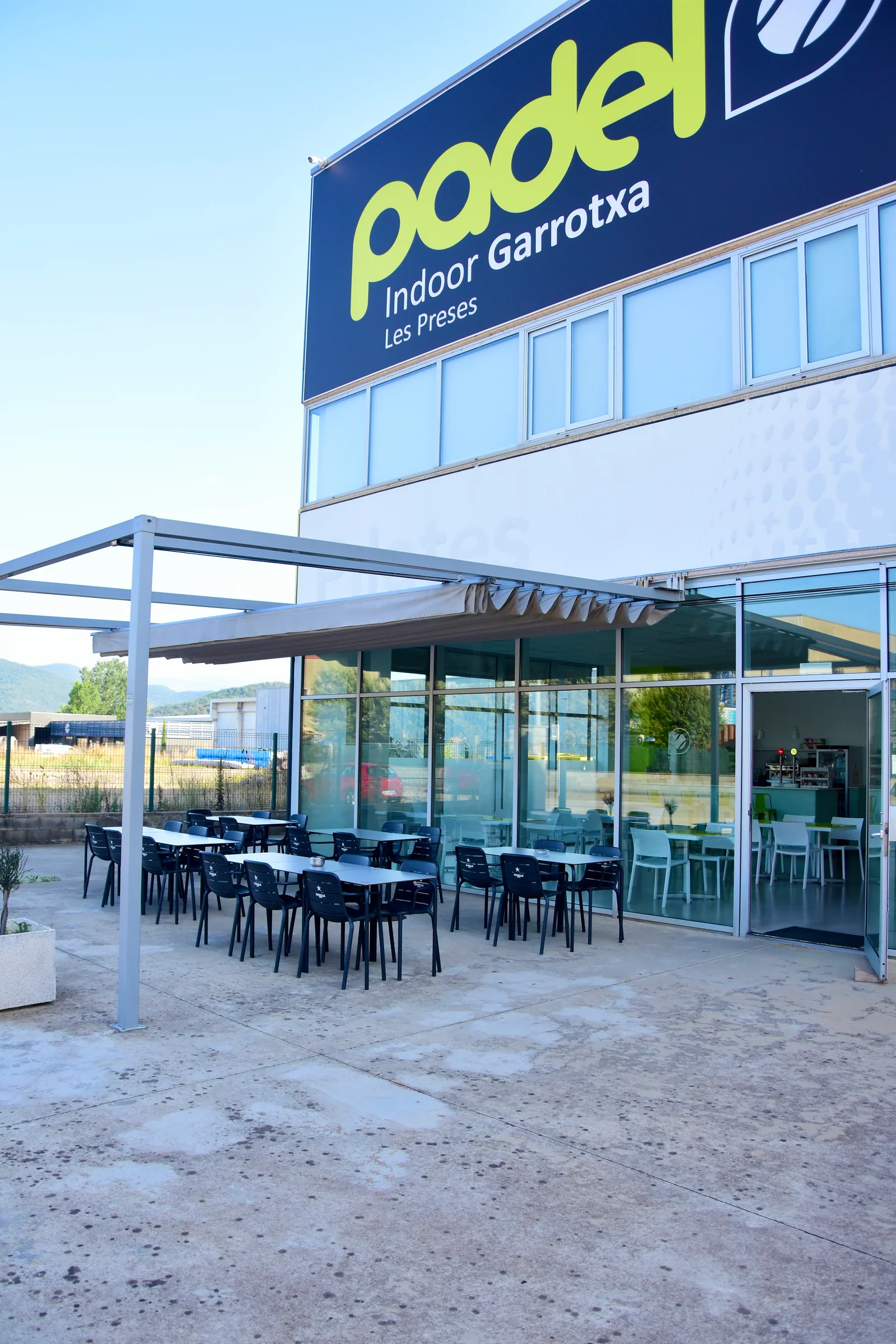 Façana de Pàdel Indoor Garrotxa a Les Preses, amb la terrassa al davant.